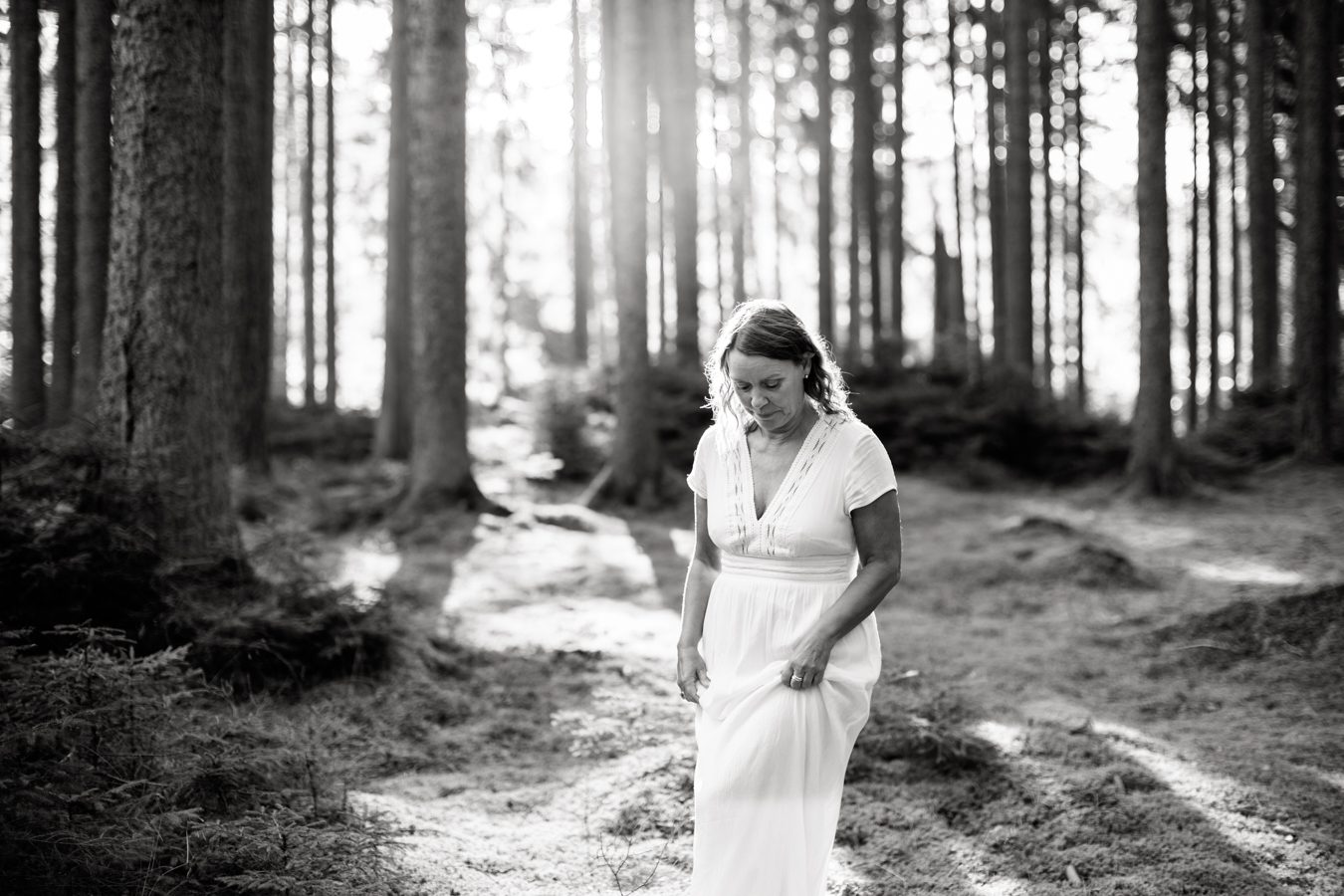 a black and white photo of coach Ulrika Hederberg walking in a forest